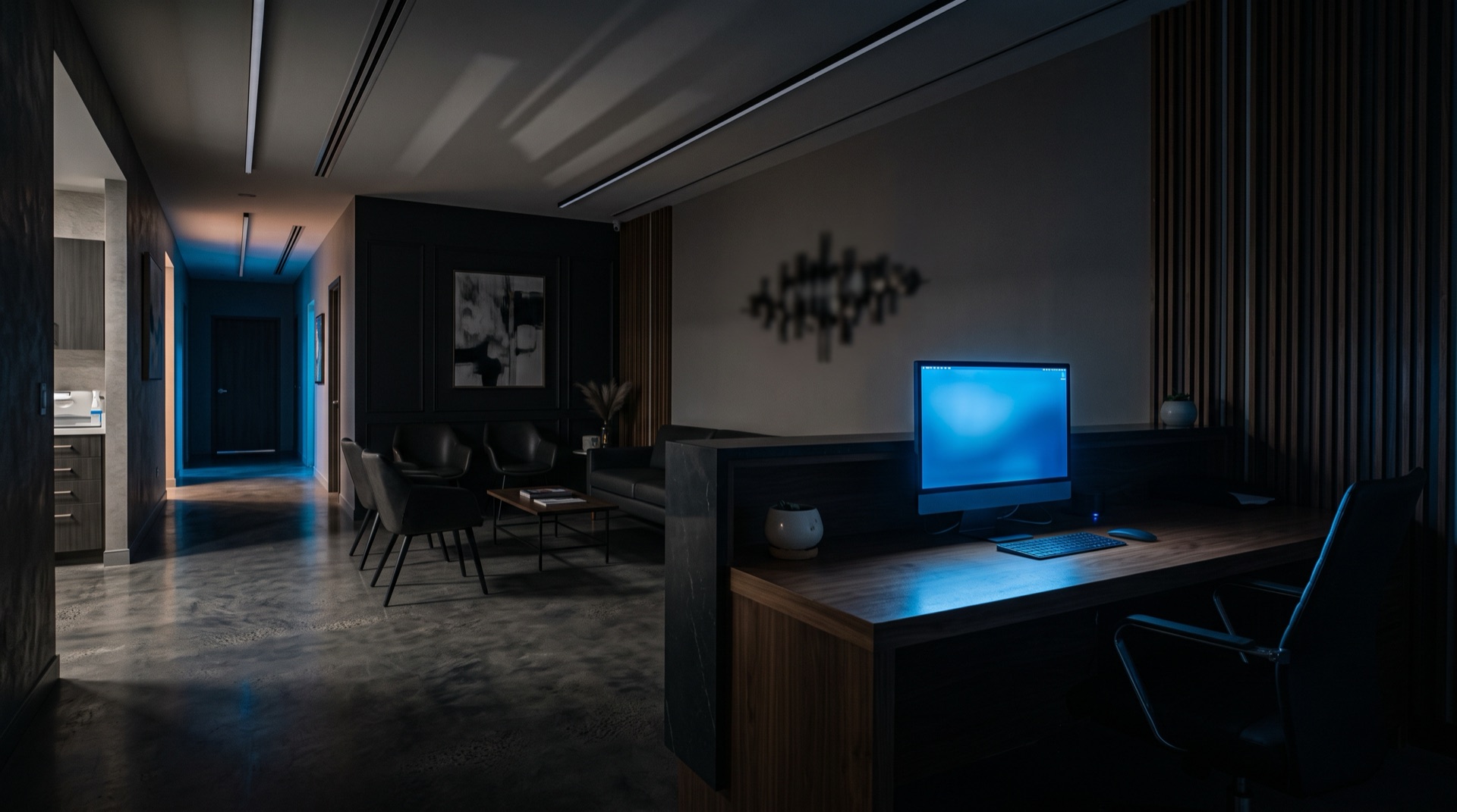A modern clinic reception at night, lit by a single screen